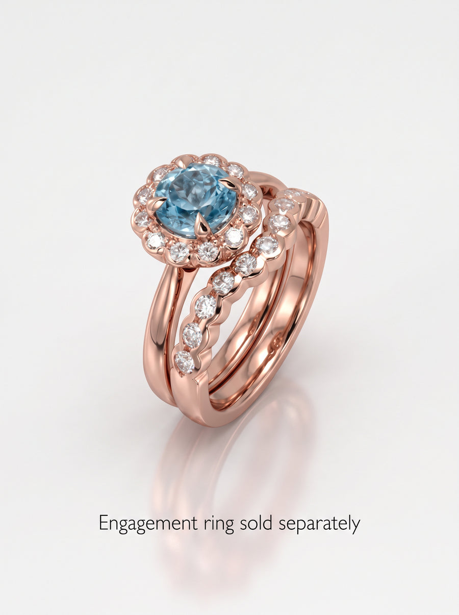 Rose gold scalloped wedding band featuring a row of round diamonds, shown paired with a blue gemstone ring.