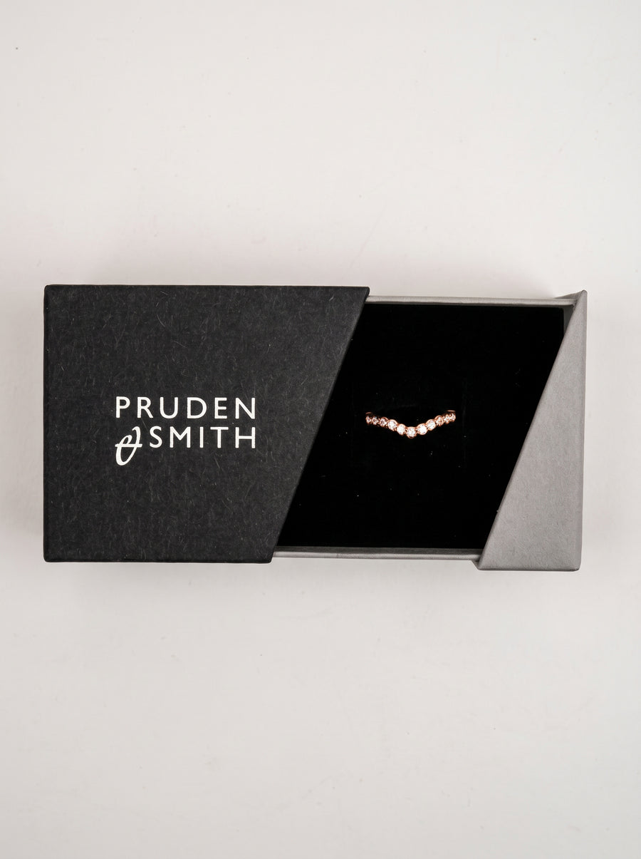 Rose gold scalloped wedding band with round diamonds in a black jewelry box.