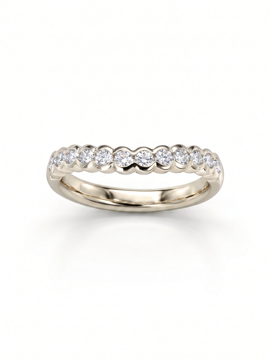 Gold wedding band with a scalloped edge and round diamonds set in a row.