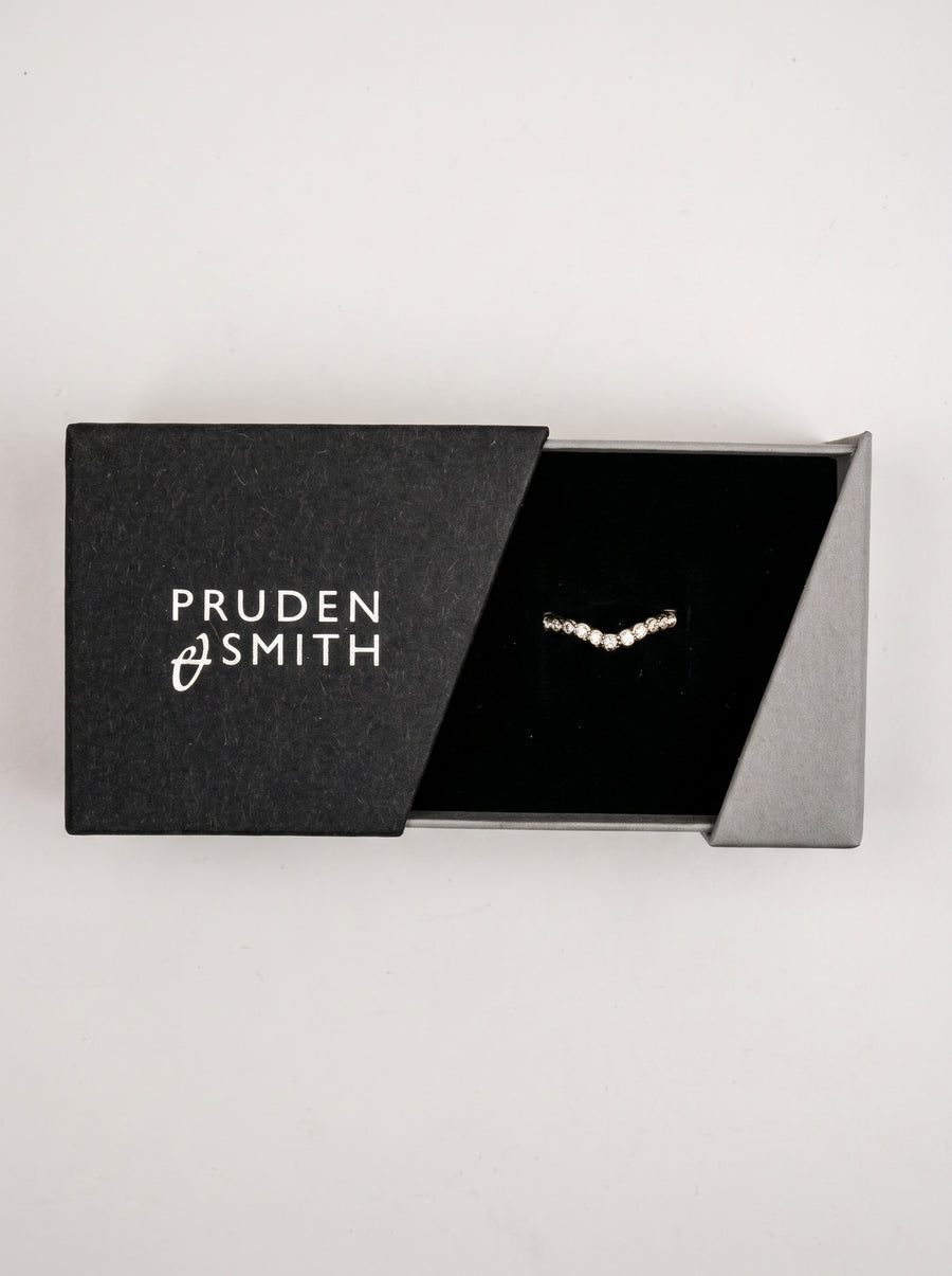 Scalloped diamond wedding band in a v-shape setting, displayed inside a black jewelry box.