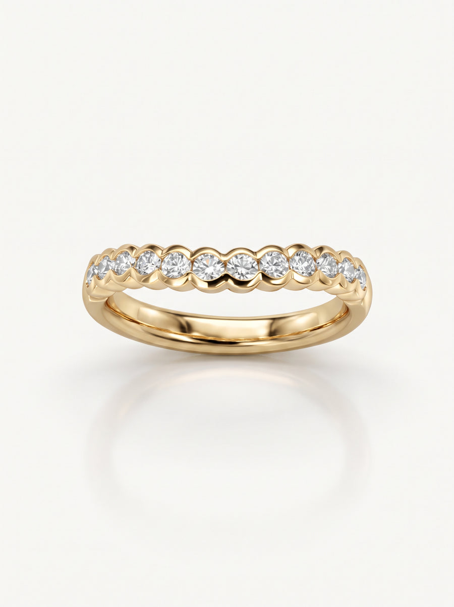 Gold wedding band featuring a scalloped design set with round brilliant diamonds.