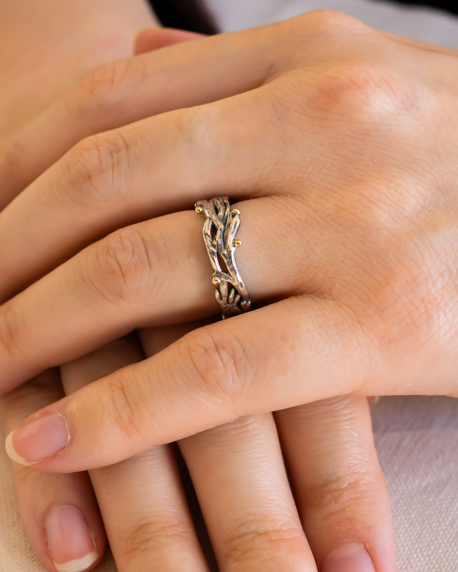 Hand wearing an organic textured silver and gold wedding ring with unique twig design