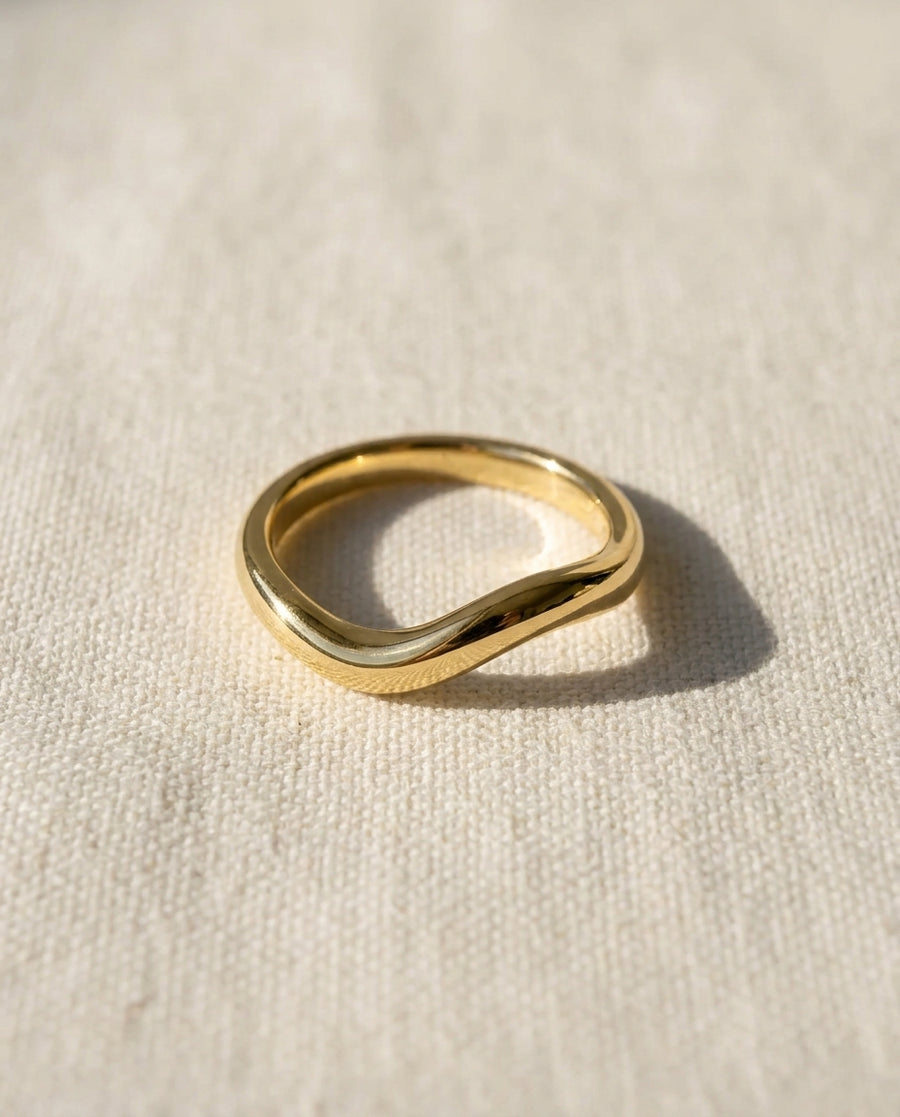 9ct yellow gold 2mm shaped court wedding ring on a light fabric.