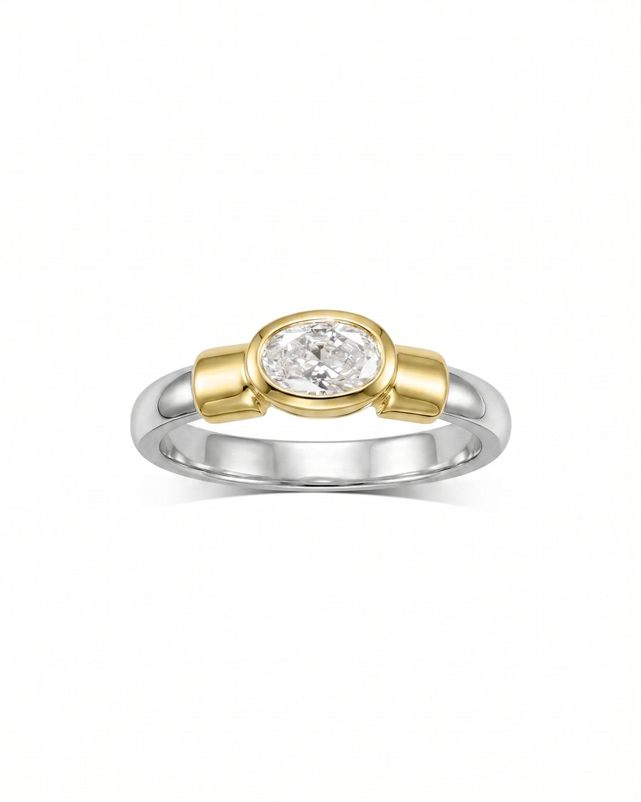 Mixed metal ring with an oval diamond in a yellow gold bezel setting.