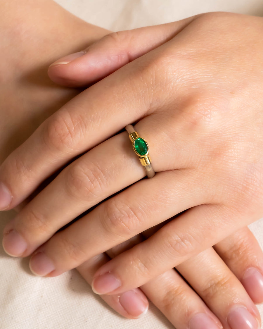 Gold and silver ring with an oval emerald gemstone.