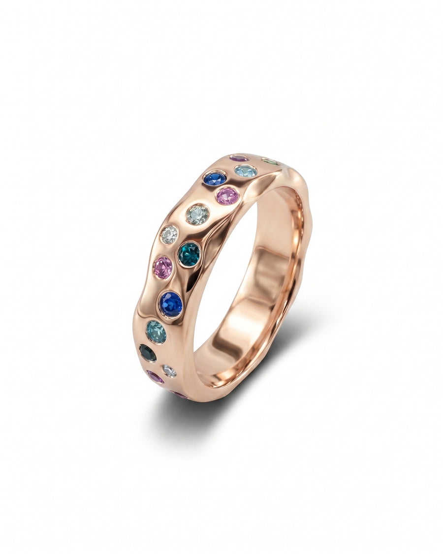Rose gold side hammered eternity ring with colorful gemstones.