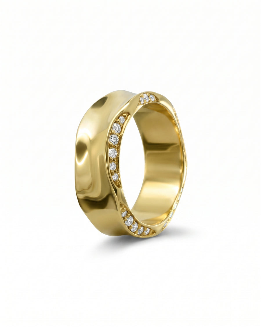 Gold eternity ring with side hammered edge and diamond accents.
