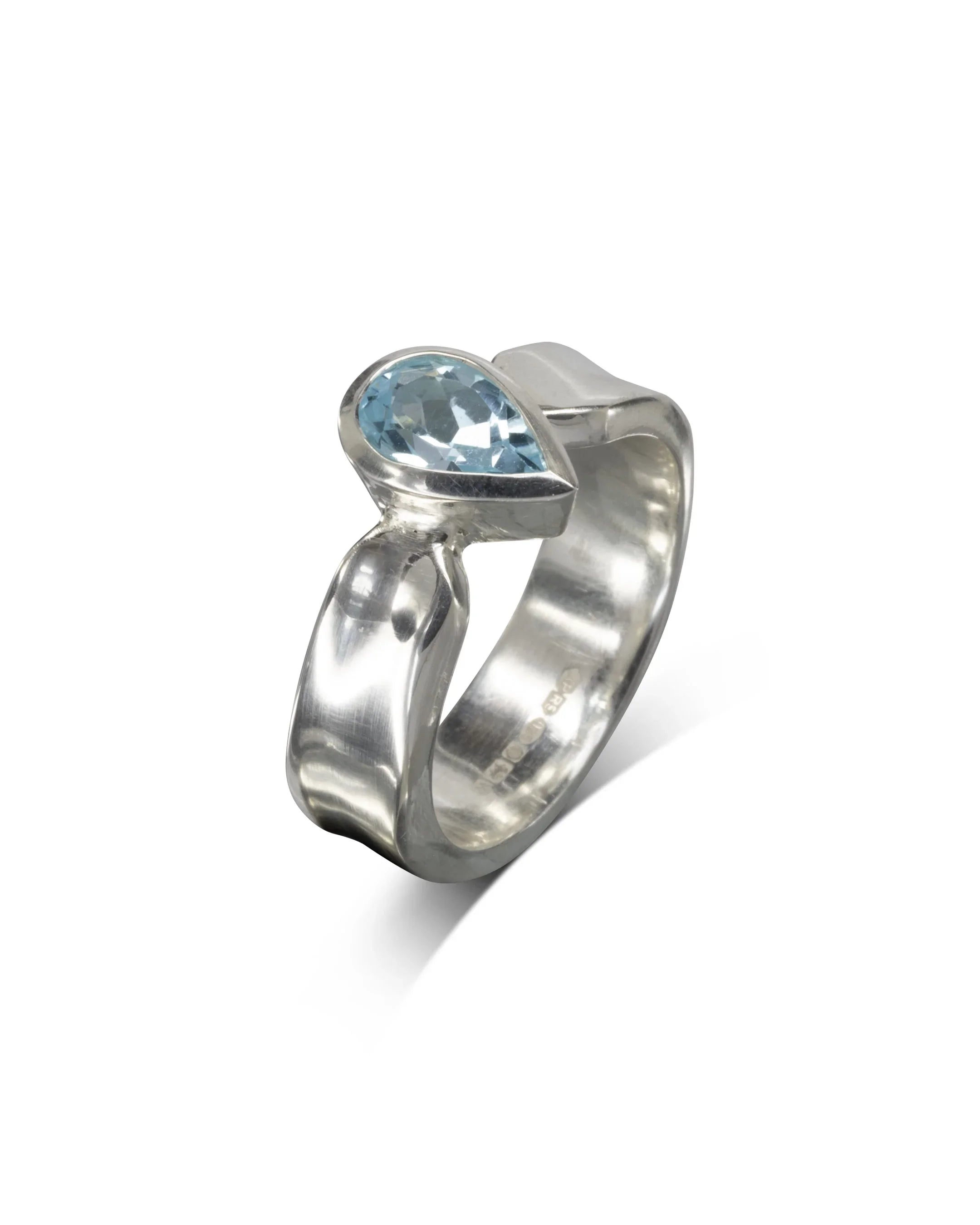 Silver side hammered ring with a pear-shaped blue gemstone.