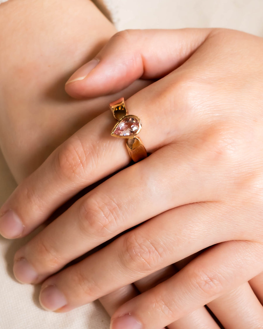 Rose gold ring with a pear-shaped pink gemstone.