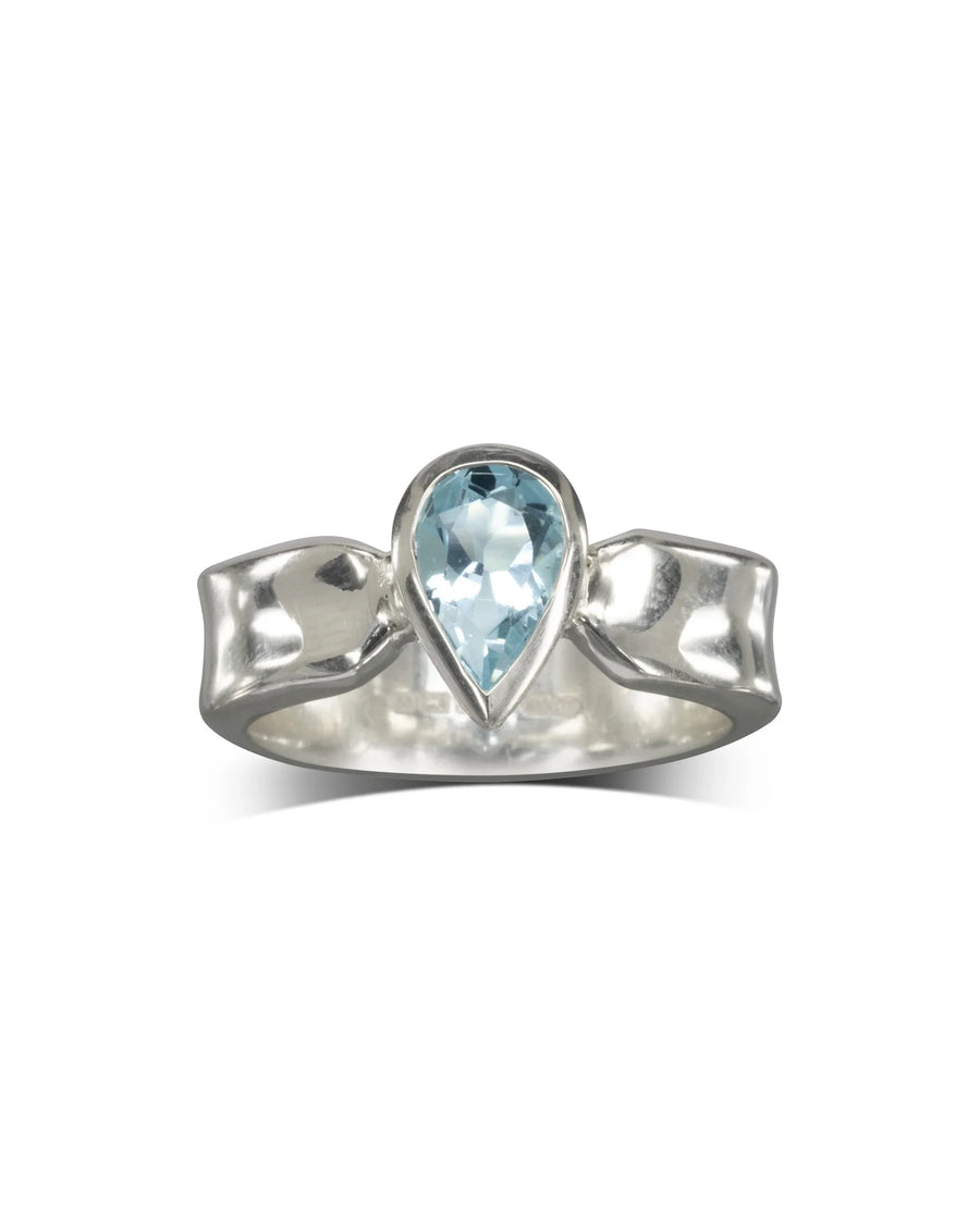 Silver side hammered ring with a pear shaped blue gemstone.