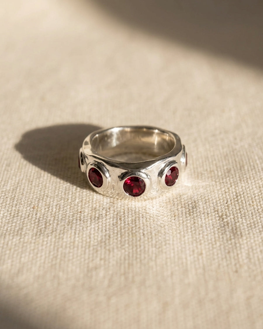 9ct white gold eternity ring with side hammered texture and round rubies.