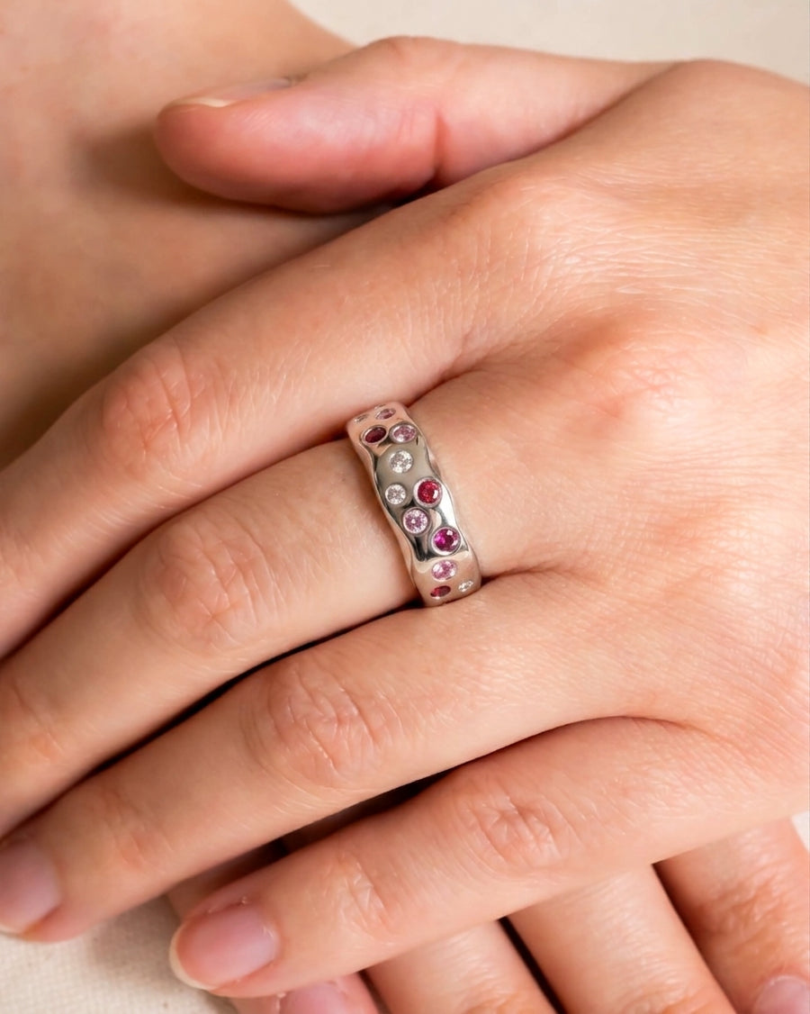 Silver eternity ring with side hammered ruby, pink sapphire, and diamond gemstones.