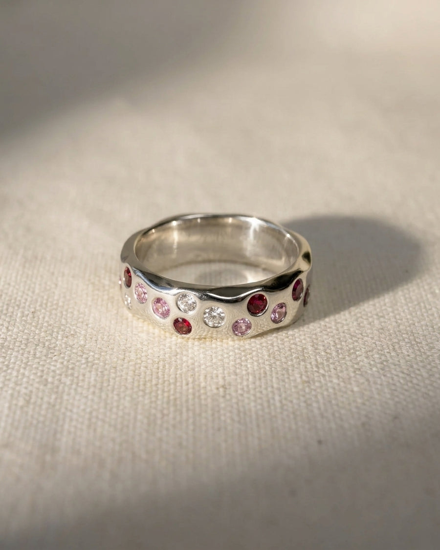 White gold eternity ring with ruby, pink sapphire, and diamond gemstones.