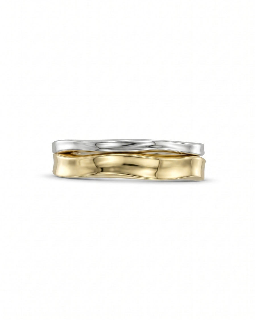 Two-tone gold and silver wedding ring set with a hammered, wavy design on a white background.