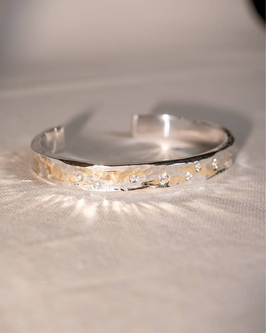 Handcrafted silver cuff bracelet with textured gold accent and scattered gemstones