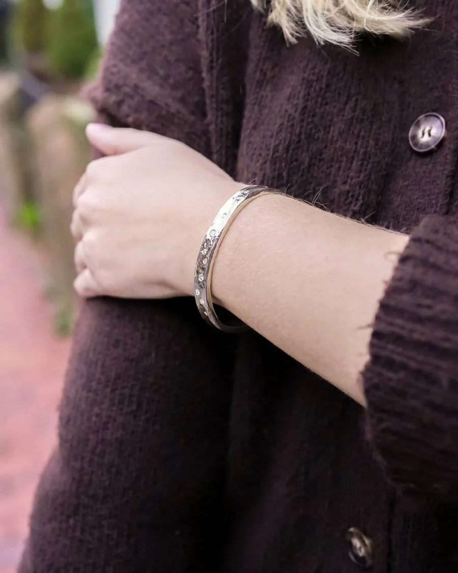 Woman wearing handmade luxury bangle bracelet with organic shapes and textured details