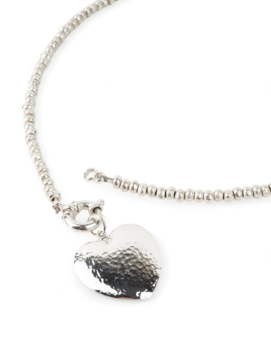 Silver nugget necklace with hammered heart pendant on white background