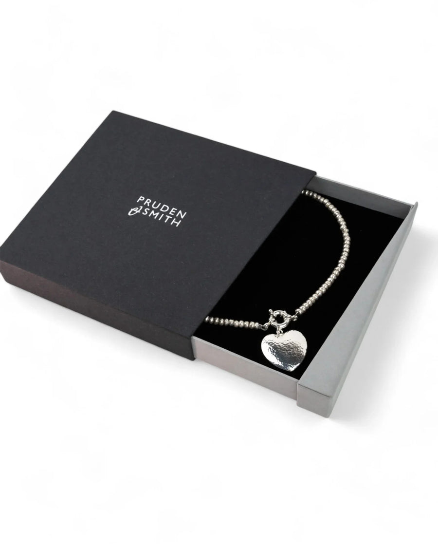 Silver nugget necklace with hammered heart pendant displayed in a gift box