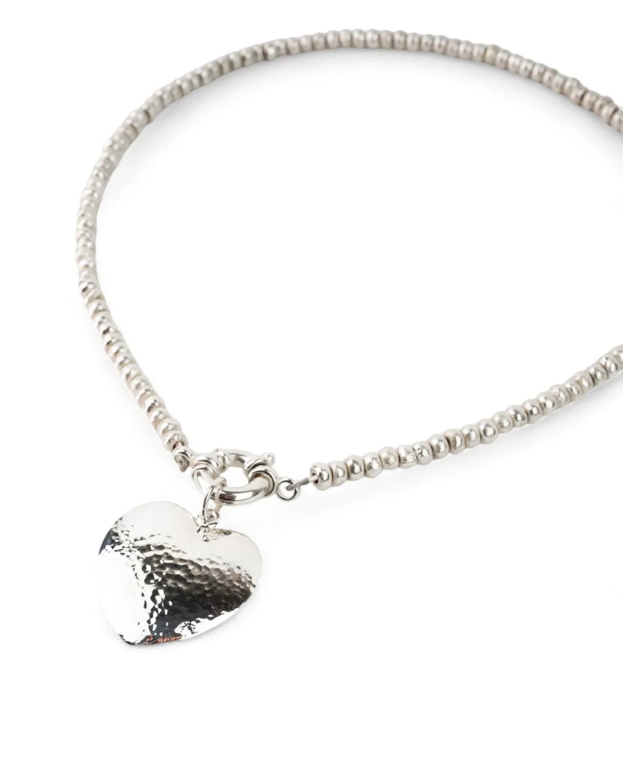 Silver nugget bead necklace with hammered heart pendant on white background