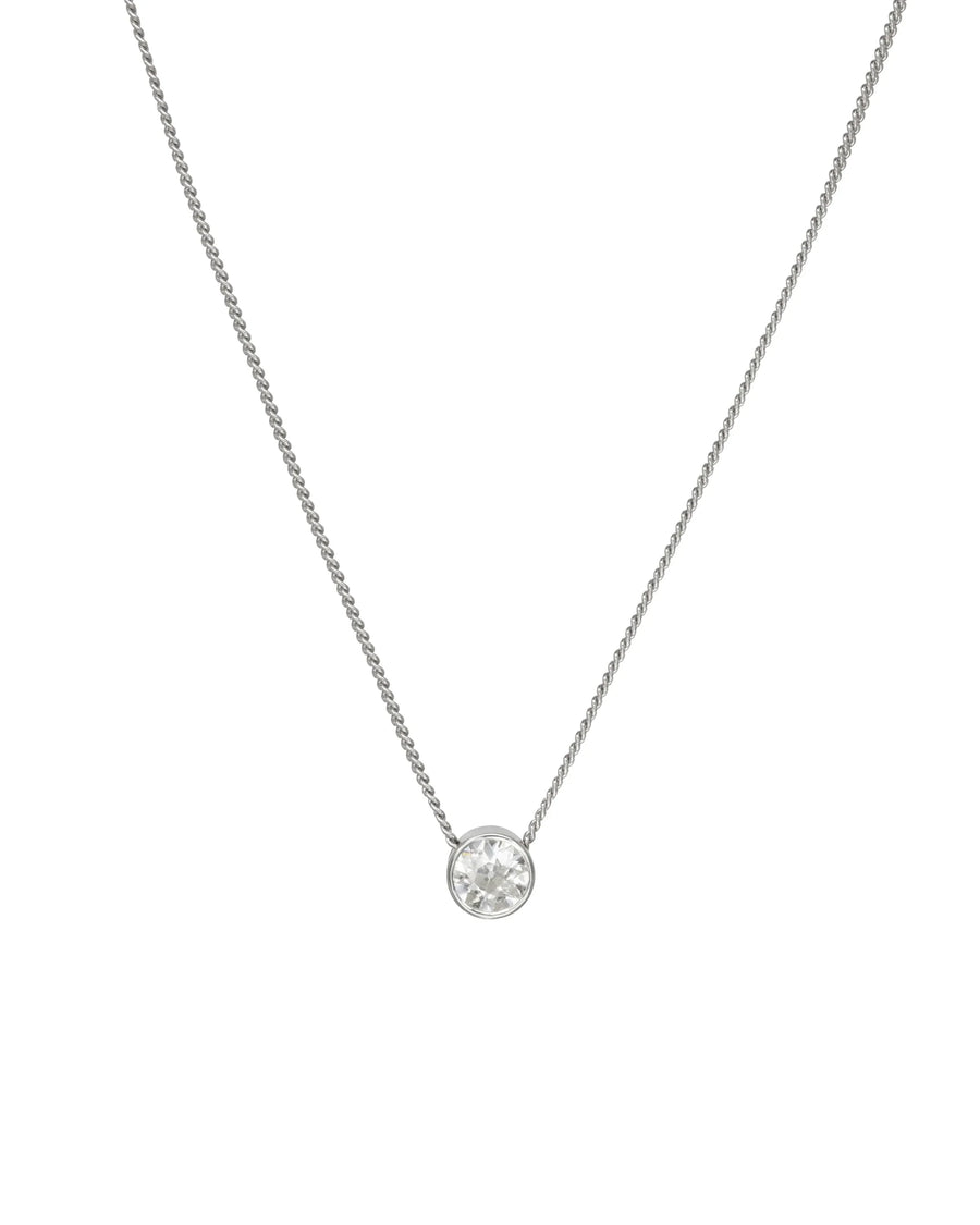 Round diamond pendant in a silver bezel setting on a delicate matching chain.