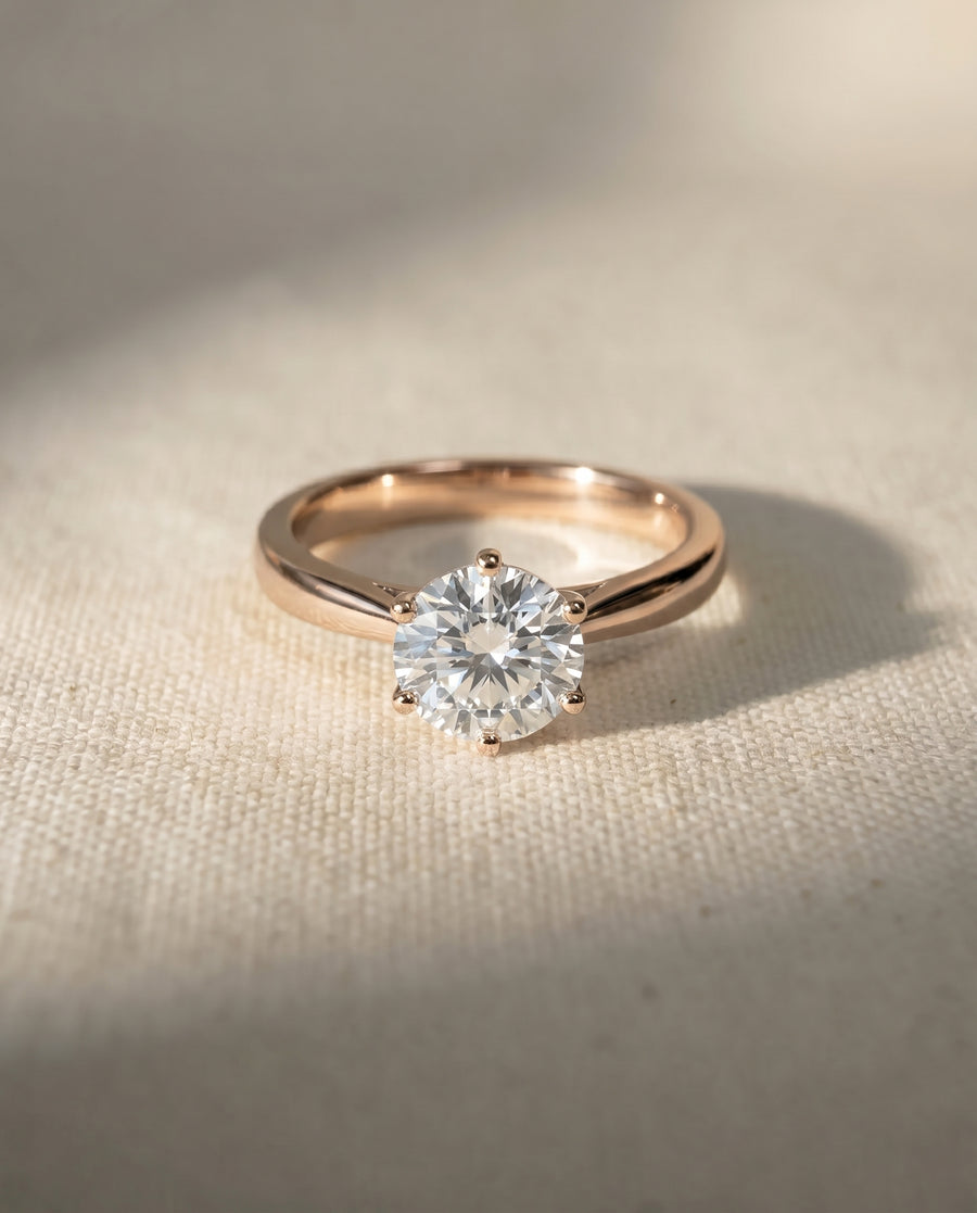 Rose gold engagement ring with a round diamond in a six-claw setting.