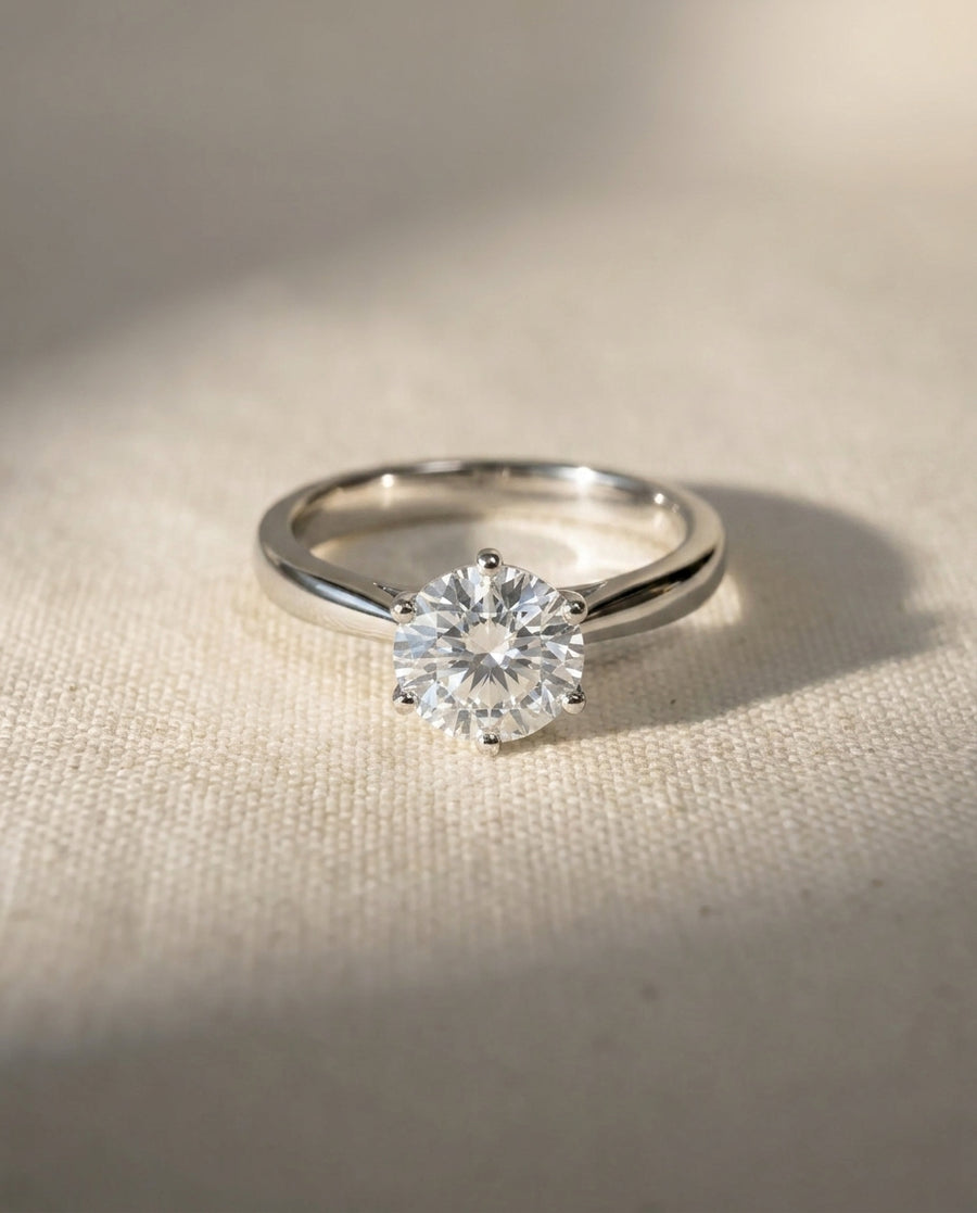 Platinum engagement ring with a round brilliant diamond in a six-claw setting.