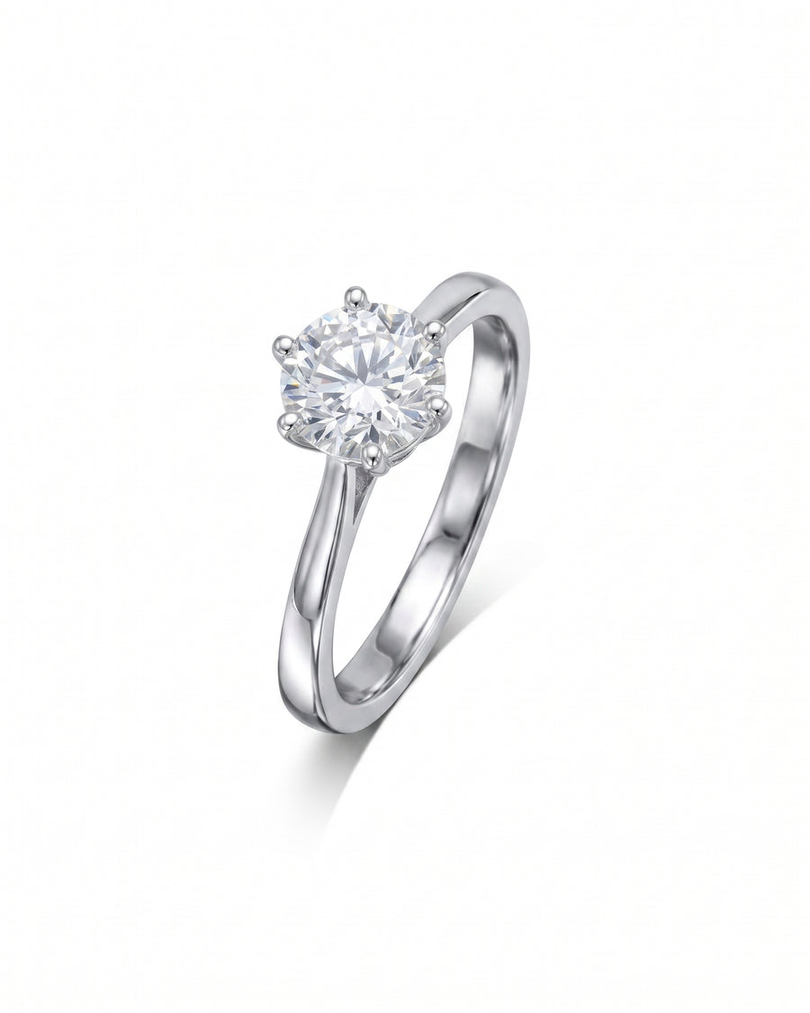 Silver six claw solitaire engagement ring with a round diamond.
