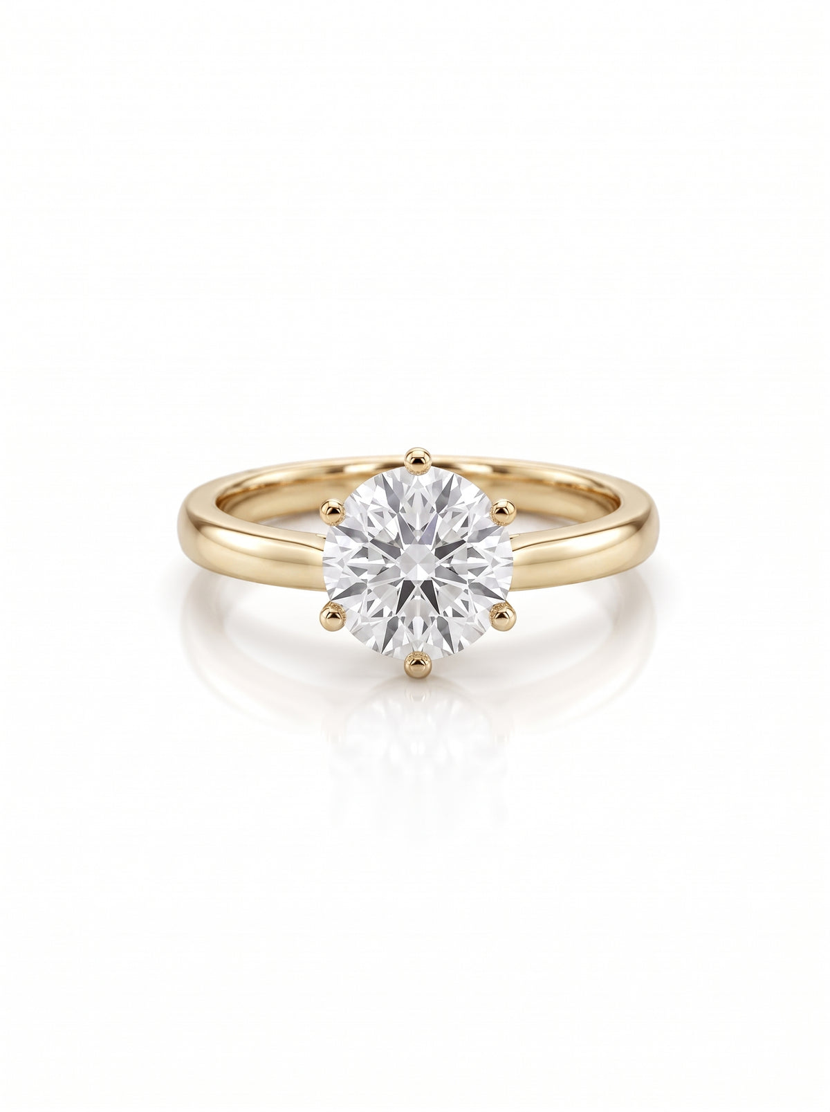 Round brilliant diamond solitaire engagement ring in a six-claw yellow gold setting on a white background.