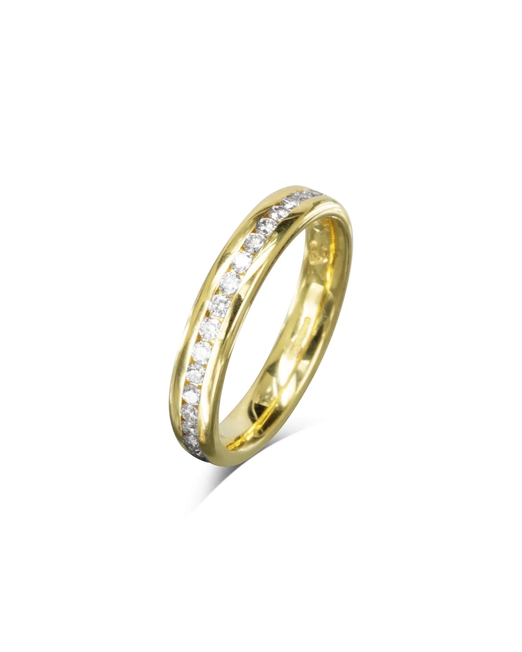 Slim gold eternity ring with channel set diamonds on white background