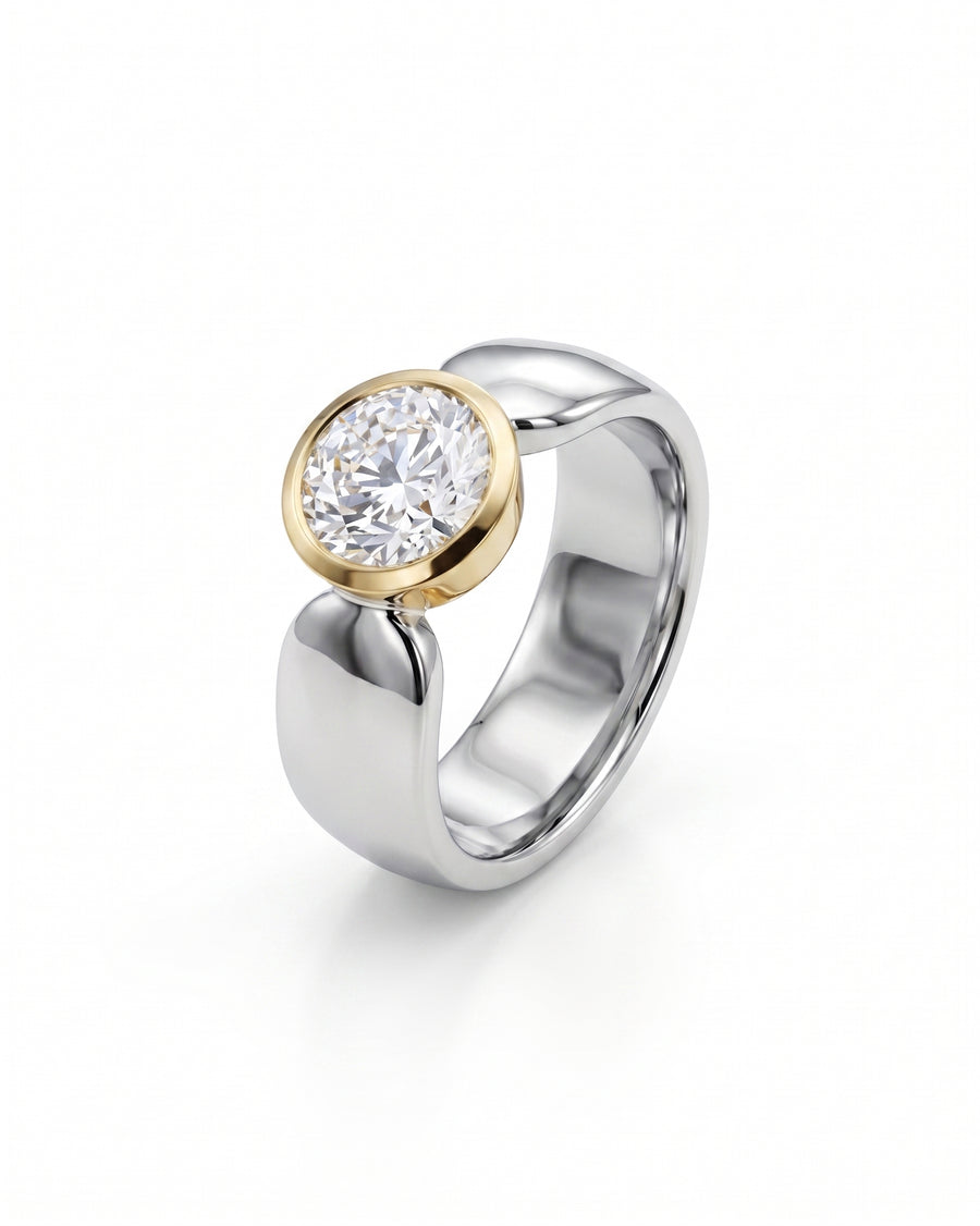 Two-tone solitaire engagement ring with a round diamond in a yellow gold bezel setting.