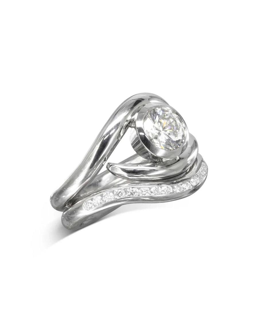 Silver spiky engagement ring with a round diamond and a curved wedding band with small diamonds.