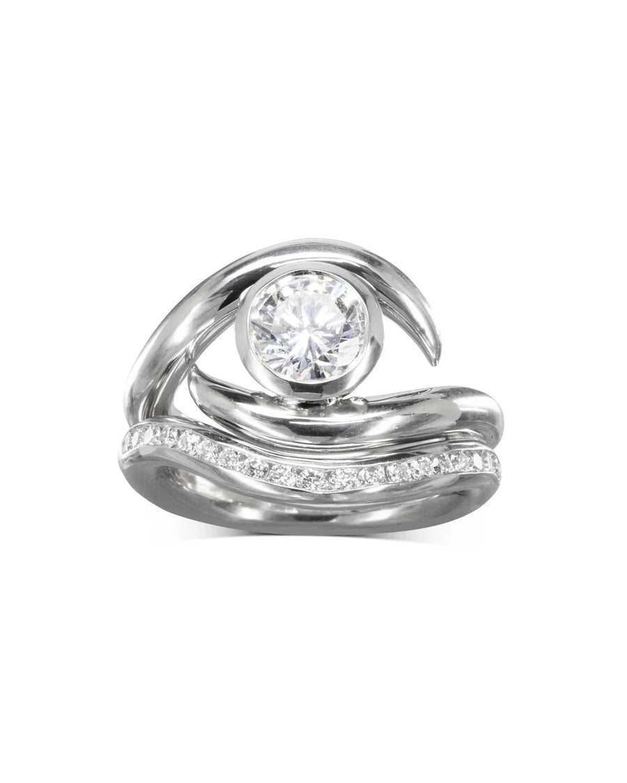 Silver spiky engagement ring with a round diamond and a curved diamond wedding band.