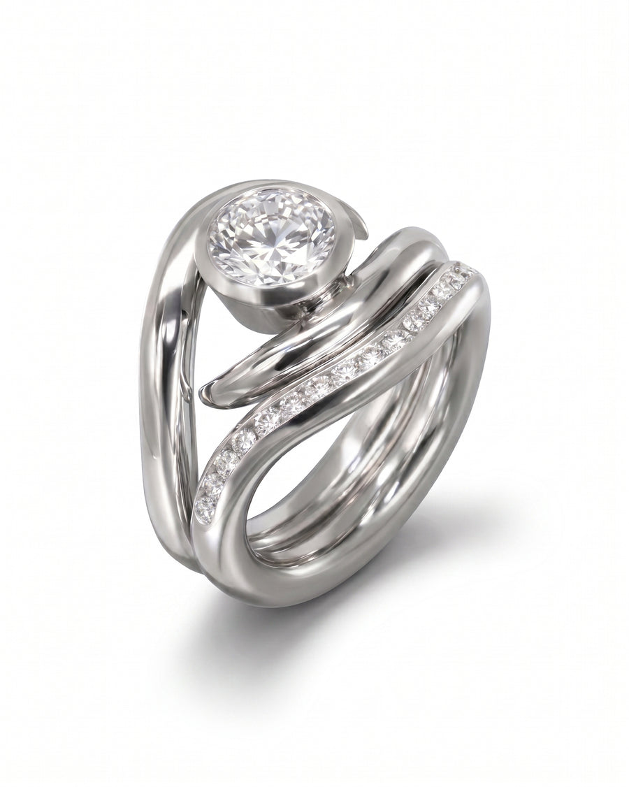 Silver engagement ring with a round diamond and a curved wedding band with pavé diamonds.