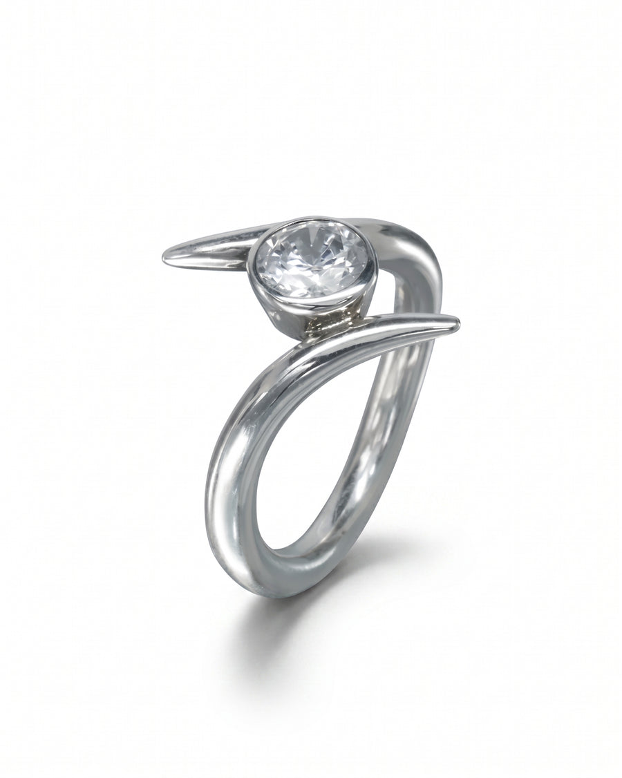 Silver spiky engagement ring with a round clear gemstone.