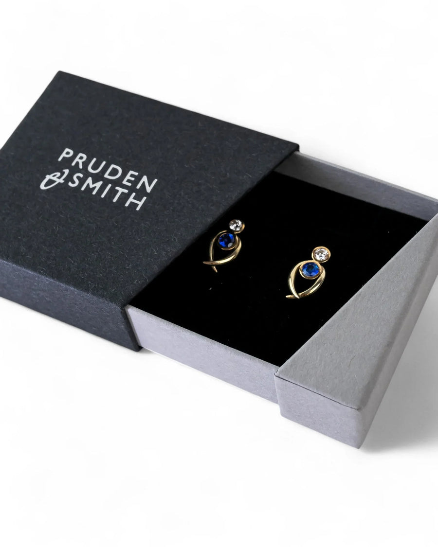 Yellow gold stud earrings with blue sapphires and diamonds in a gift box