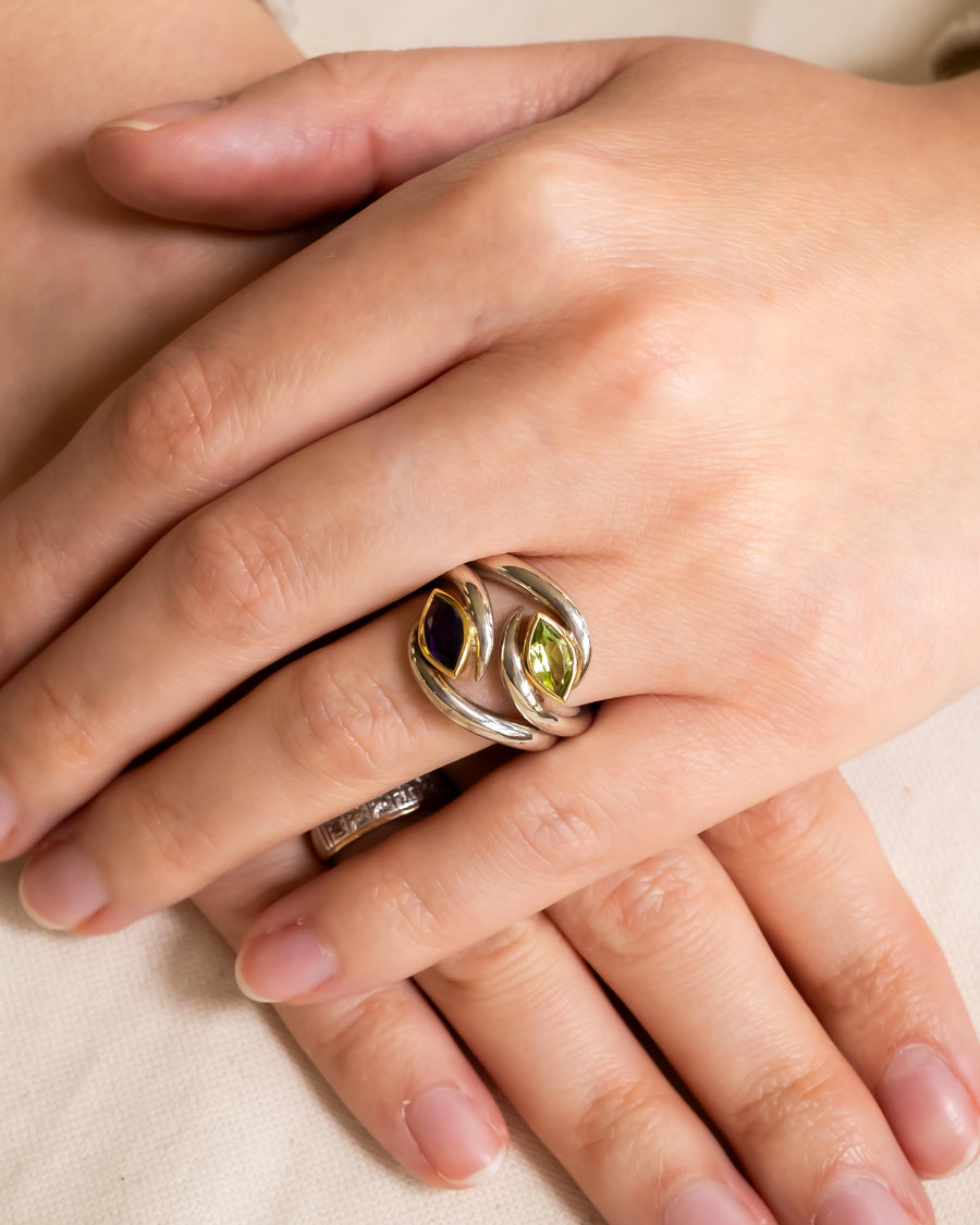 Silver and gold ring with purple and green marquise gemstones.