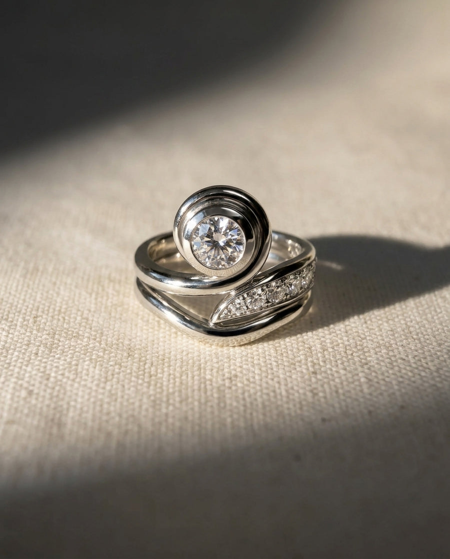 Platinum engagement ring with a round diamond and pavé diamonds.