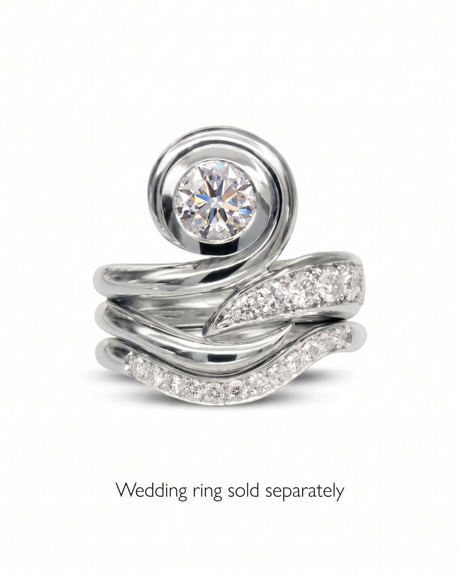 Platinum engagement ring with a round diamond and pavé diamond wedding band.