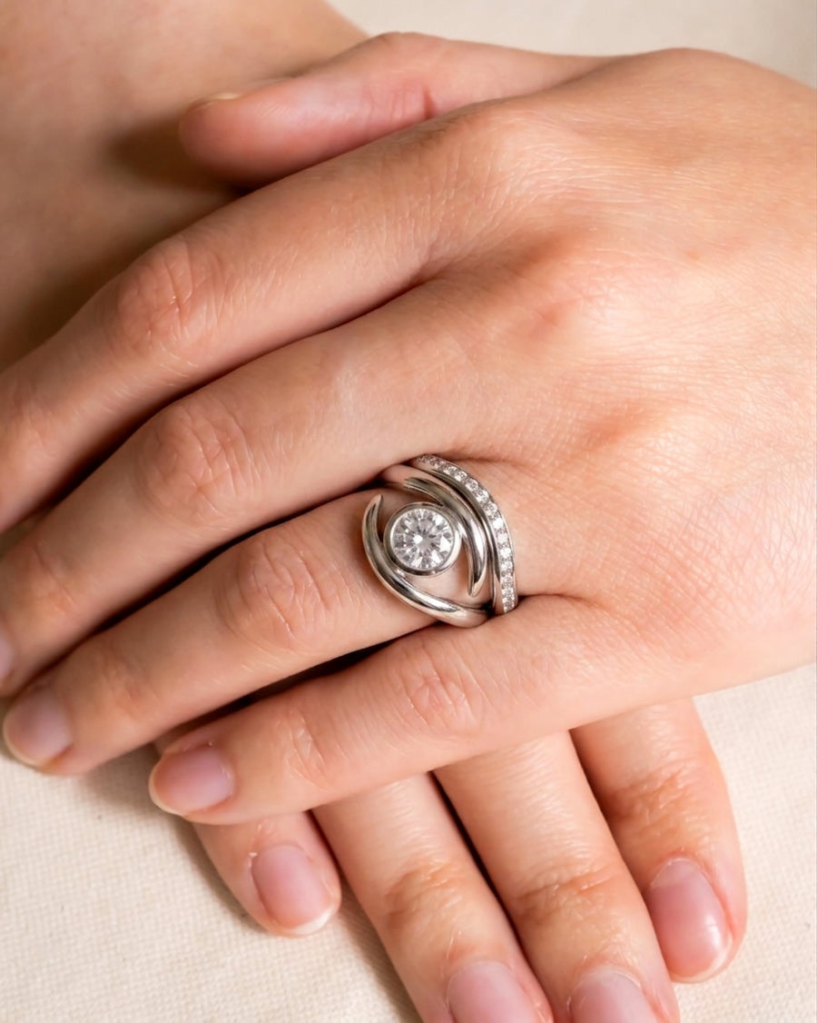 Platinum curved fitted ring with a round diamond center and pavé diamond accents.