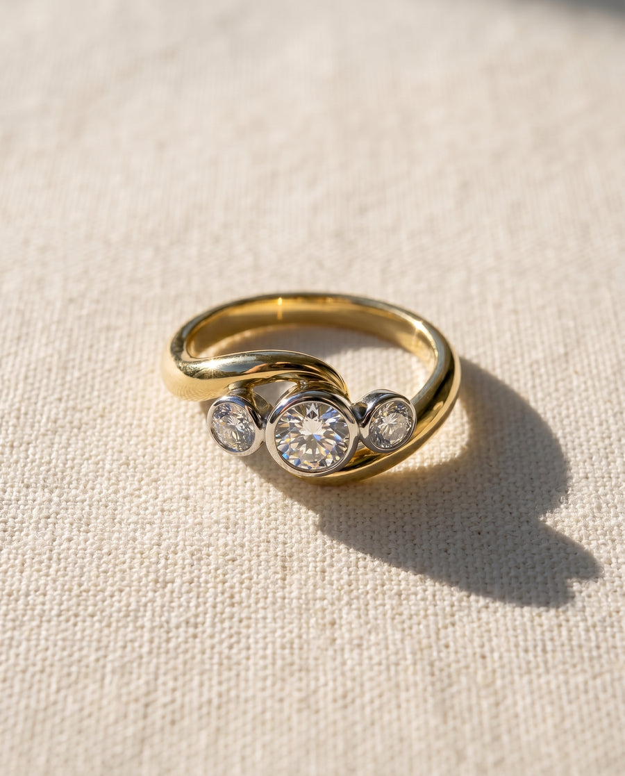 Platinum and 18ct yellow gold engagement ring with three round diamonds.