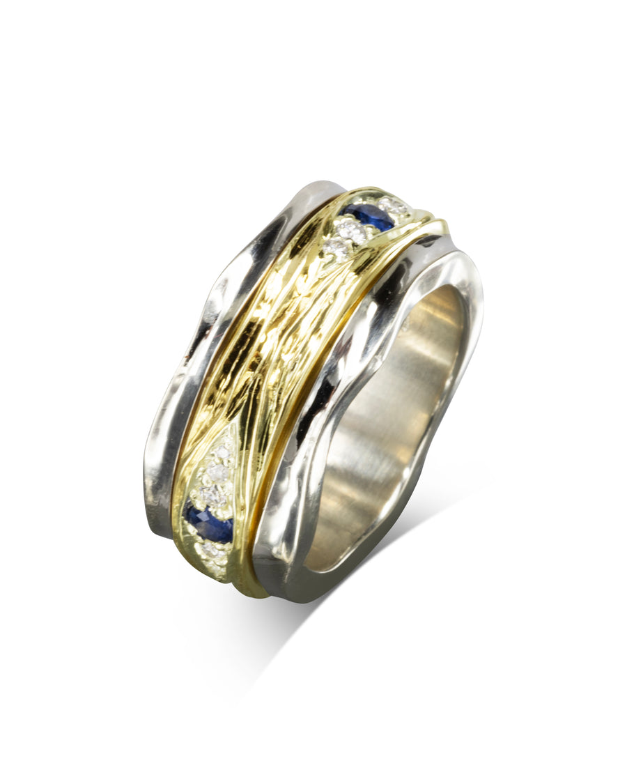 Two-tone spinning ring with gold, silver, diamonds, and blue sapphires.