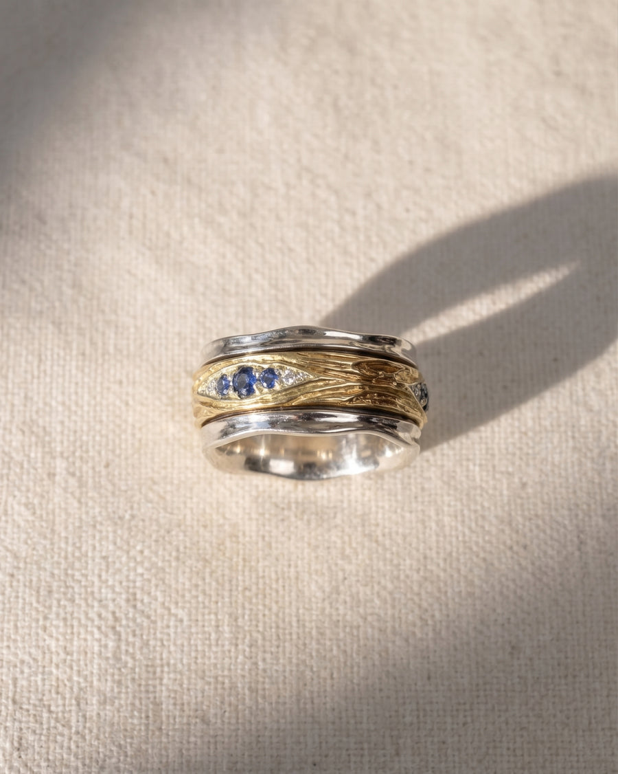 9ct white and yellow gold spinning ring with blue sapphires and diamonds.