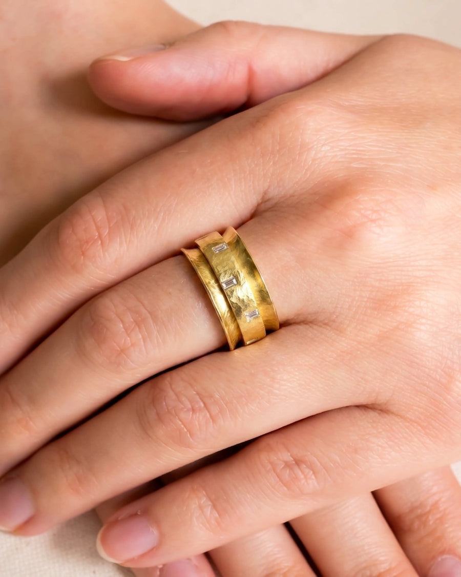 Yellow gold baguette cut diamond eternity ring on a hand.
