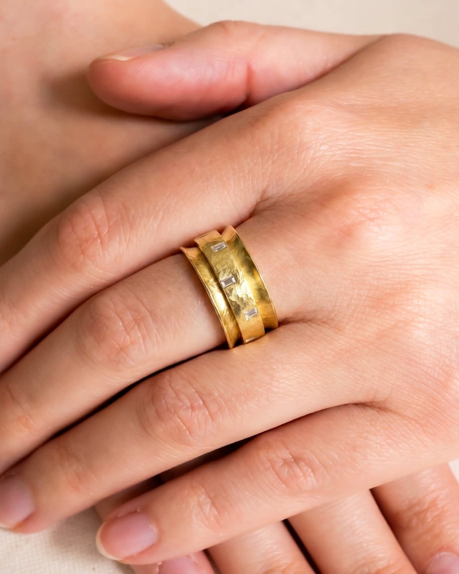 Yellow gold baguette cut diamond eternity ring on a hand.