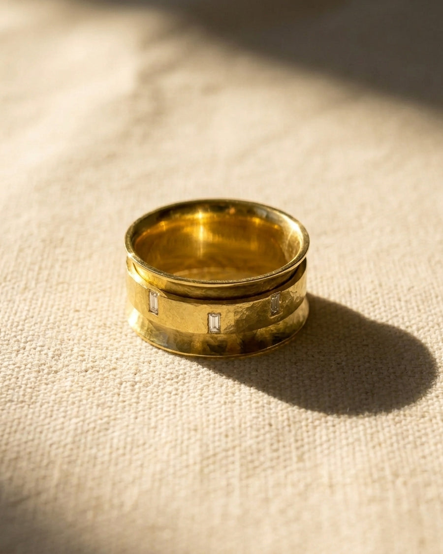 Yellow gold spinning eternity ring with baguette cut diamonds.