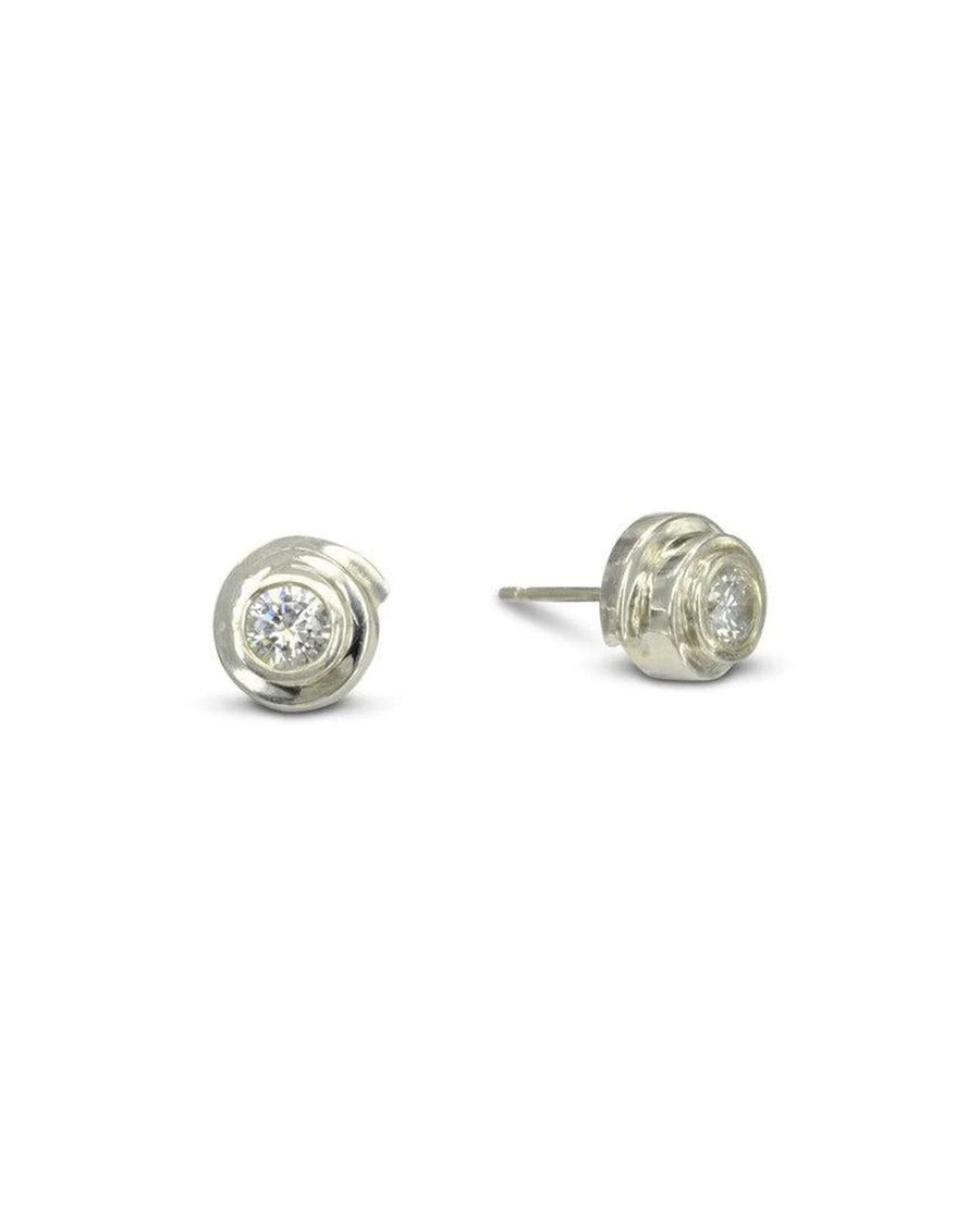 Silver spiral stud earrings with a round diamond in a bezel setting.