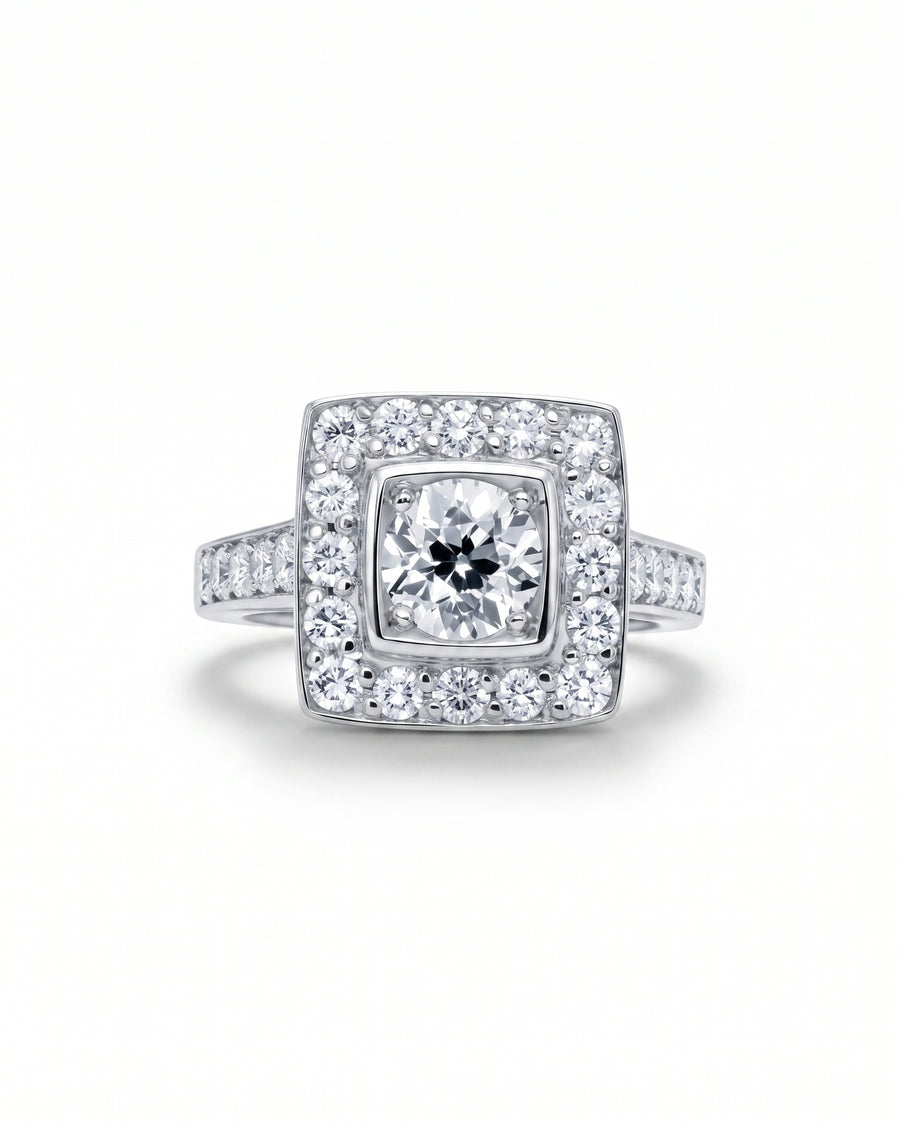White gold square cluster engagement ring with diamond shoulders.