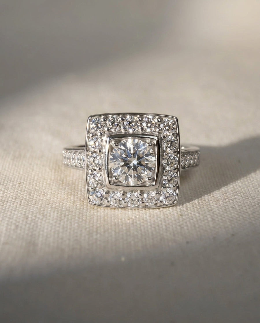 Platinum square cluster engagement ring with diamond shoulders.