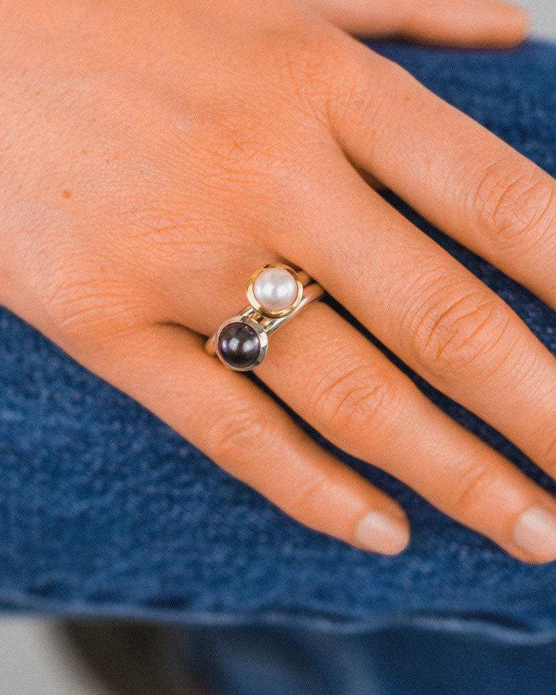 Silver and gold stackable rings with white and black round pearls.