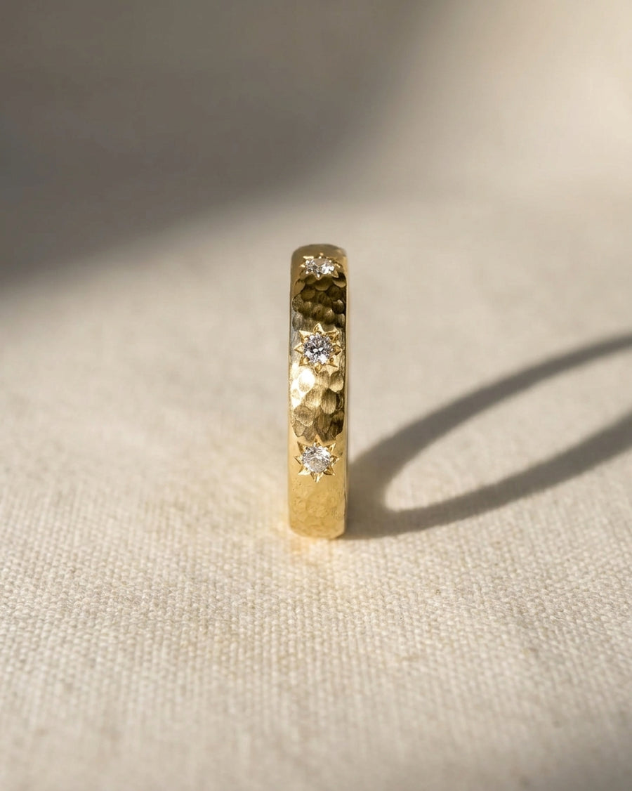 Gold hammered ring with three star set diamonds.